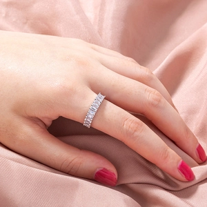 Detail of silver eternity ring with rectangular zircons on pink silk background