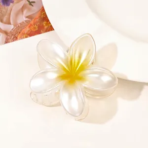 Macro shot of pearlescent plumeria flower hair claw clip with yellow gradient detail