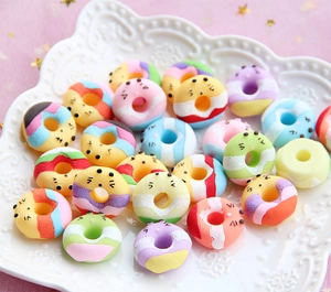 Close-up of colorful resin cartoon donuts with cute expressions on white plate