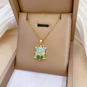 Detailed view of a gold tulip pendant with enamel inlay and sparkling zircon crystals