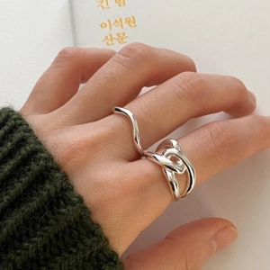 Detail of a 925 sterling silver hollow criss-cross ring with polished wavy lines
