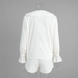 Back view of a white cotton two-piece set featuring ruffled collar and short pants details