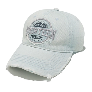 Macro detail of washed denim baseball cap with FOURTEEN embroidery and distressed edges