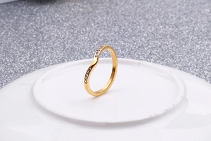 Vue détaillée de la bague dorée en forme de V ornée de cristaux blancs en serti pavé