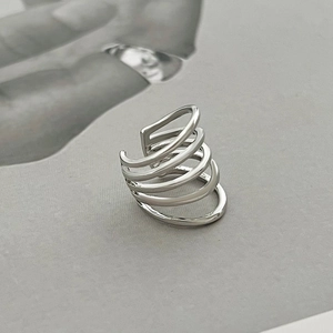 Macro shot of silver multi-layered spiral ear cuff on a textured grey surface