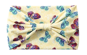 Detail of yellow bow headband featuring colorful butterfly patterns for sport and yoga