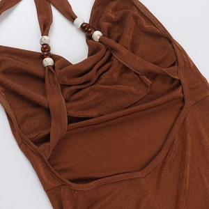 Detail of brown halter neck dress with marble white beads and amber bead accents