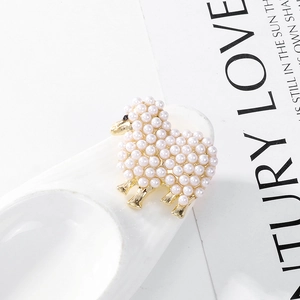 Détail de la broche mouton en métal doré avec incrustation de perles blanches