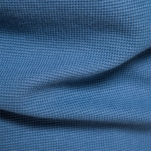 Macro du tissu en maille gaufrée bleu marine montrant la texture du t-shirt henley manches longues