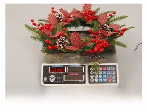 Couronne de Noël avec baies rouges et pommes de pin pesant 350g sur une balance