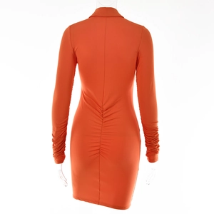 Detail view of the back ruched design and slim fit cut on this orange mini dress