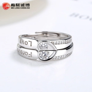 Macro detail of 925 silver couples rings with love heart puzzle and forever engraving