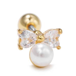 Detalle macro de pendiente de lazo dorado con circonita de corazón y perla blanca