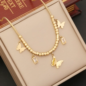 Elegant gold butterfly pendant necklace with crystal accents on a jewelry box