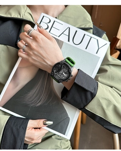 Detail of a large multifunctional sport watch with green silicone strap held by a model