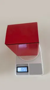 Ceramic Christmas figurine in packaging being weighed at 302.3g on a digital scale