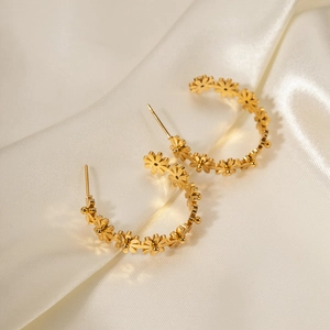 Pendientes de aro en forma de margarita dorada de acero 18K sobre seda blanca