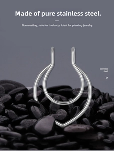 Macro detail of silver double-layered U-shaped heart nose ring on smooth stone