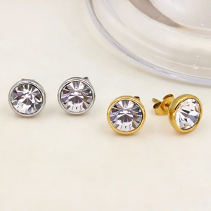 Macro shot of 18K gold and silver stainless steel round stud earrings with sparkling zircons
