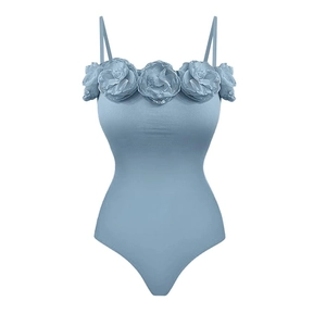 Détail du maillot de bain bleu clair avec rosettes florales 3D et fines bretelles