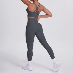 Dettaglio del set yoga grigio scuro con reggiseno sportivo incrociato e leggings a vita alta