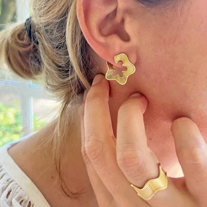 Polished gold wave design stainless steel ring and earrings set worn by model