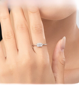 Detail of emerald cut solitaire S925 sterling silver ring on a finger close-up