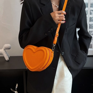 Dettaglio borsa a tracolla arancione brillante a forma di cuore con spallina regolabile