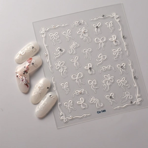 Detail of 3D embossed white bow nail stickers and pearl patterns for nail art design