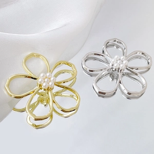 Detail view of hollow flower charms with white pearls in gold and silver finish
