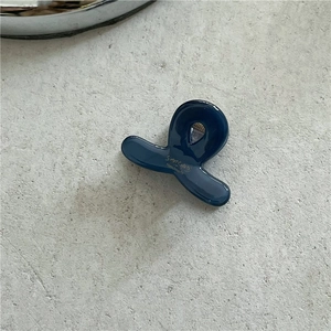 Detail of dark blue acetate hair claw clip with golden Sahara Handmade text