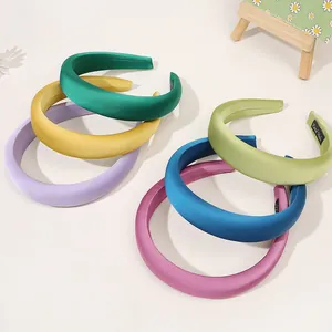 Close-up of colorful wide satin headbands set showing smooth texture and handmade labels
