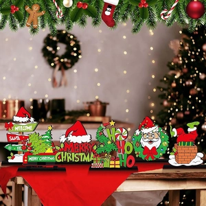 Close-up of wooden Santa and Merry Christmas tabletop signs with festive warm background