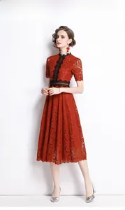 Detailed view of elegant red lace midi dress featuring intricate black floral embroidery