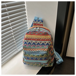 Detailed view of colorful ethnic pattern weave and metal zippers on a crossbody bag