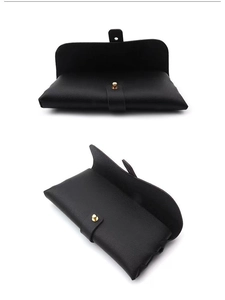 Detail of black pebbled leather sunglasses pouch with elegant gold stud button closure