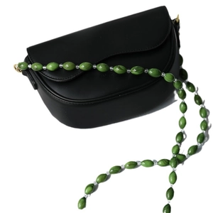 Minimalist black crescent shoulder bag with a unique green and clear beaded acrylic chain