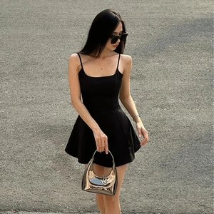 Robe noire chic à fines bretelles avec bordure en dentelle, fente latérale et sac argenté