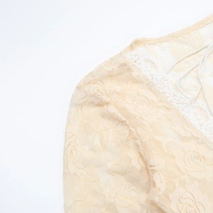 Close-up of beige floral lace fabric detail on the U-neck long sleeve dress