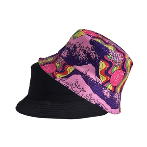 Detail of reversible bucket hat showing black side and colorful wave print canvas texture