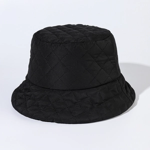 Detail of the black quilted bucket hat featuring diamond-pattern stitching and nylon texture