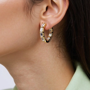 Close-up of 18K gold-plated hoop earrings with rectangular cut white zircon stones