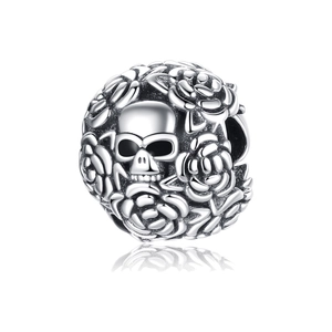 Macro detail of silver skull charm bead with hollow rose texture and polished finish