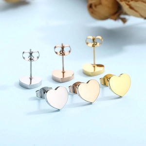 Polished heart stud earrings in silver, gold, and rose gold finishes on blue background