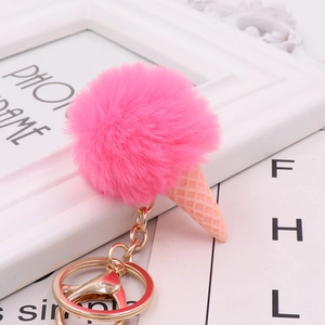 Close-up of fluffy rose pink pompom ice cream cone keychain with golden lobster clasp