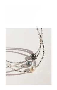 Detailed view of triple-layered silver bead necklace with black, grey, and white pearls