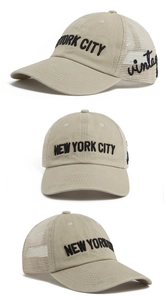 Close-up of New York City and vintage embroidery on beige washed cotton trucker hat