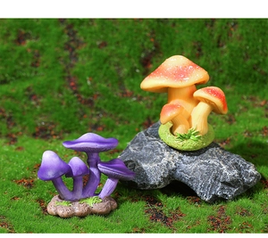 Detail of purple and orange resin mushroom figurines on moss for fairy garden
