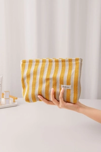 Macro detail of yellow striped canvas bag with herringbone texture and H&R BAG label