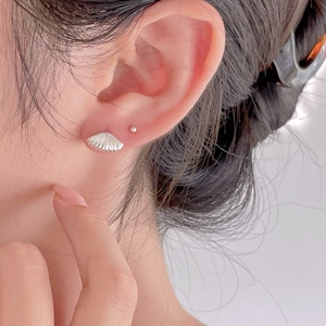 Minimalist 925 sterling silver shell stud earrings set with metallic texture on ear